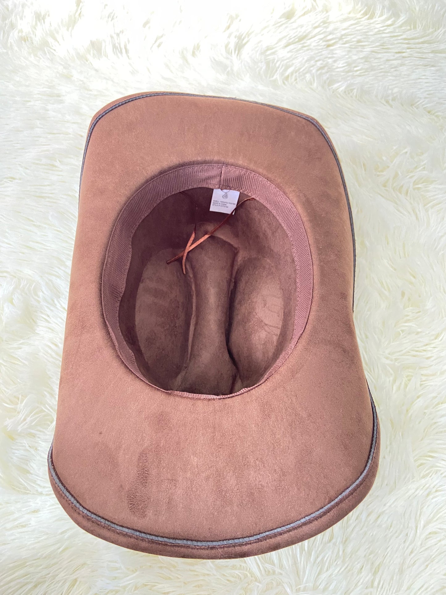 Sombrero, marron oscuro con placas de corazón al rededor en plateado, estilo vaquero.
