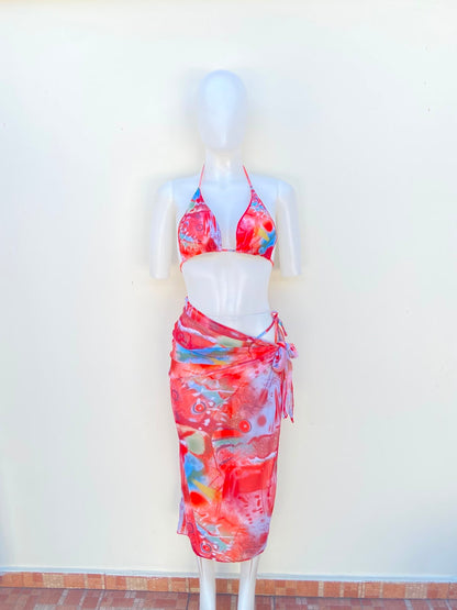 Biquini, de tres piezas con color rojo y coral combinados con detalles azules, verdes, amarillos, blancos y rosados.