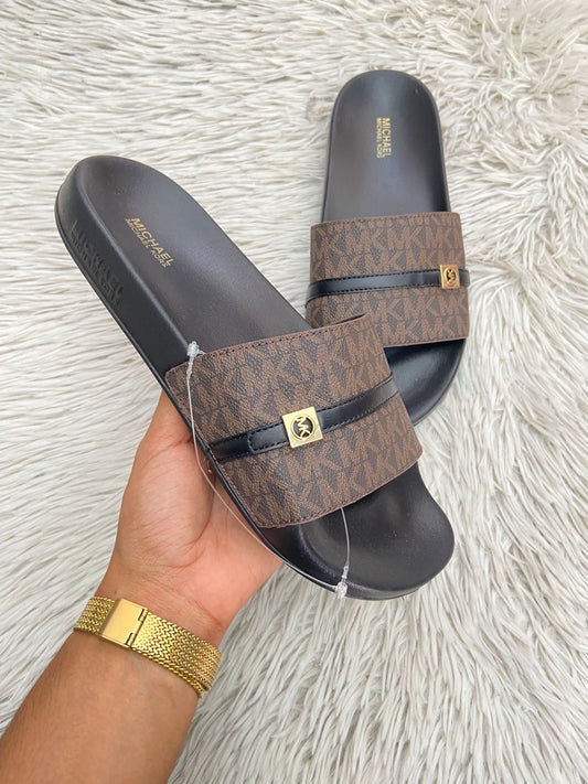 Sandalias MICHAEL KORS original, negra con marrón y correa en frente con placa MK en dorado.