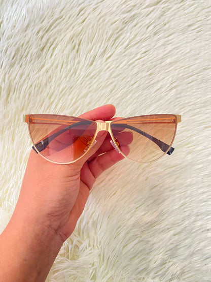 Lentes, negro con montura dorada micas marrones y patillas negras.