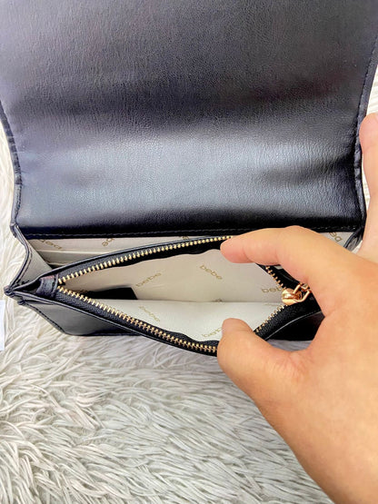 Cartera BEBE Original, negro con nombre de la marca al frente en color dorado, correa tipo cadena enlazada con tela negra.
