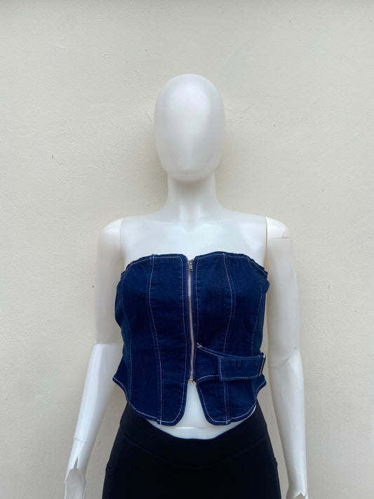 Top jean azul, con zíper al frente y detalle de lazo ajustable.