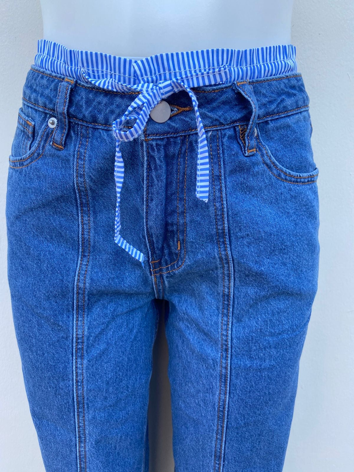 Pantalon jean azul liso con tela con lazos ajustable color azul arriba de la pretina, ancho.