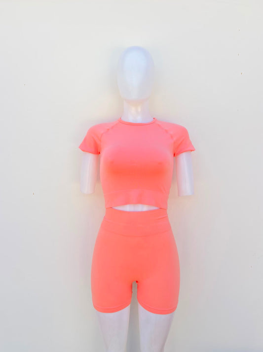 Conjunto, color naranja claro (durazno/coral), de leggign corta y top.
