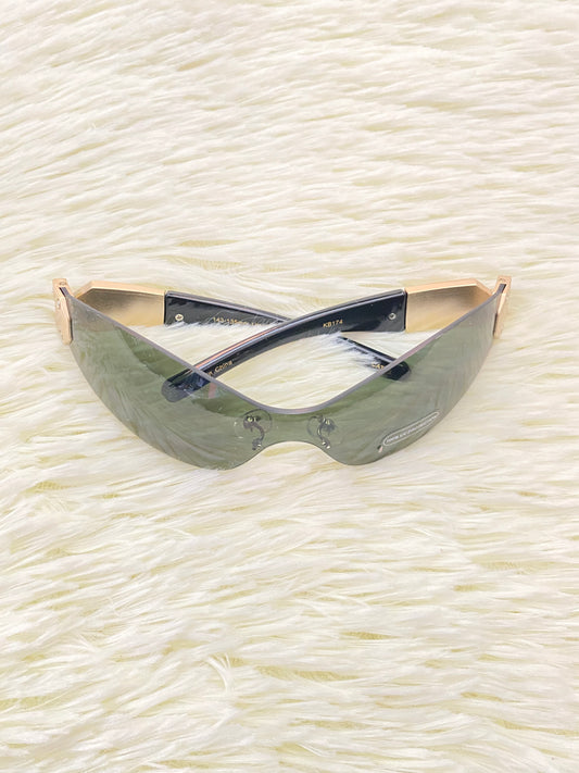 Lentes con micas verde oliva y detalle en color dorado atrás.