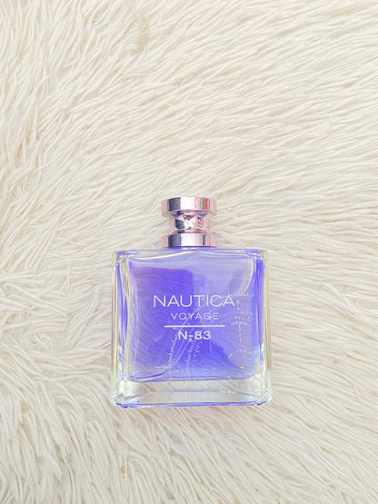 Perfume NAUTICA VOYAGE N- 83 original, azul marino con fondo de una brújula.