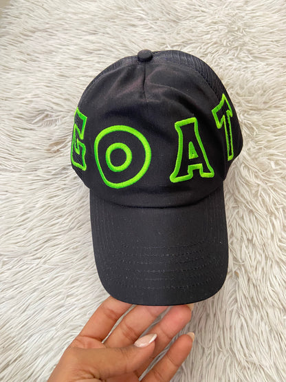 Gorra negra con letras GOAT en verde ( la cabra )