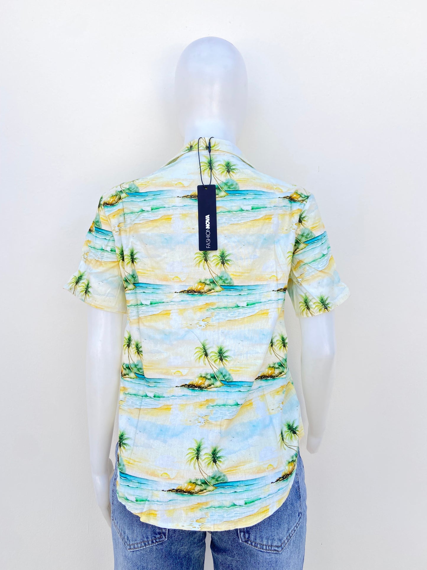 Camisa, amarilla con verde y estampado de playa con palmeras.