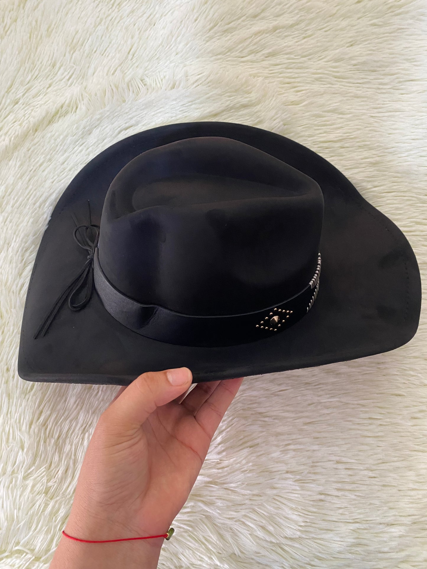 Sombrero, negro con detalles de hilos blancos y detalle de puntos dorados.
