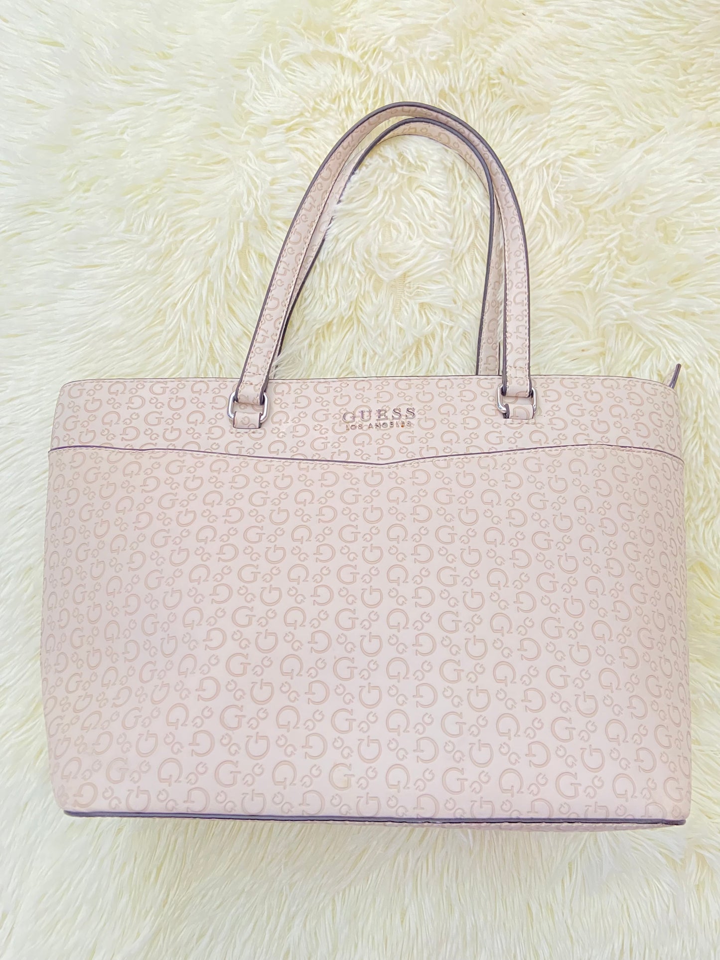 Cartera GUESS original, grande, rosado palo crema con letras G y placa GUESS en plateado en frente.