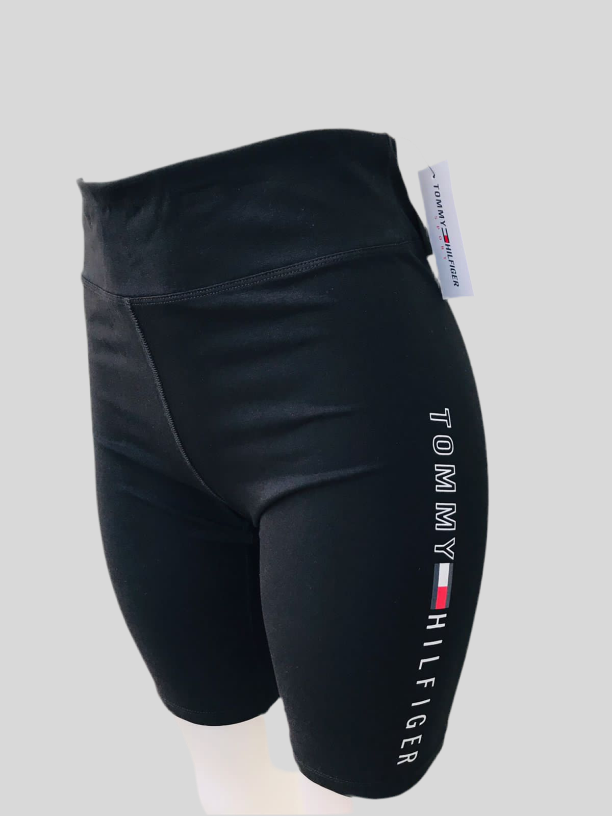 Legging licra Tommy Hilfiger original de color negra talle alto con diseño de letras y logo TOMMY HILFIGER en blanco de lado