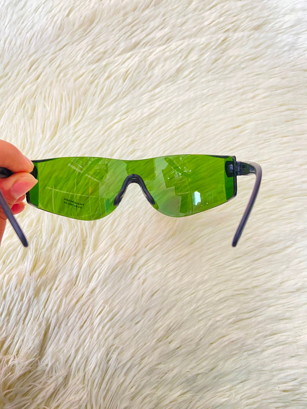 Lentes, sin montura con micas en color verde y patillas negras.