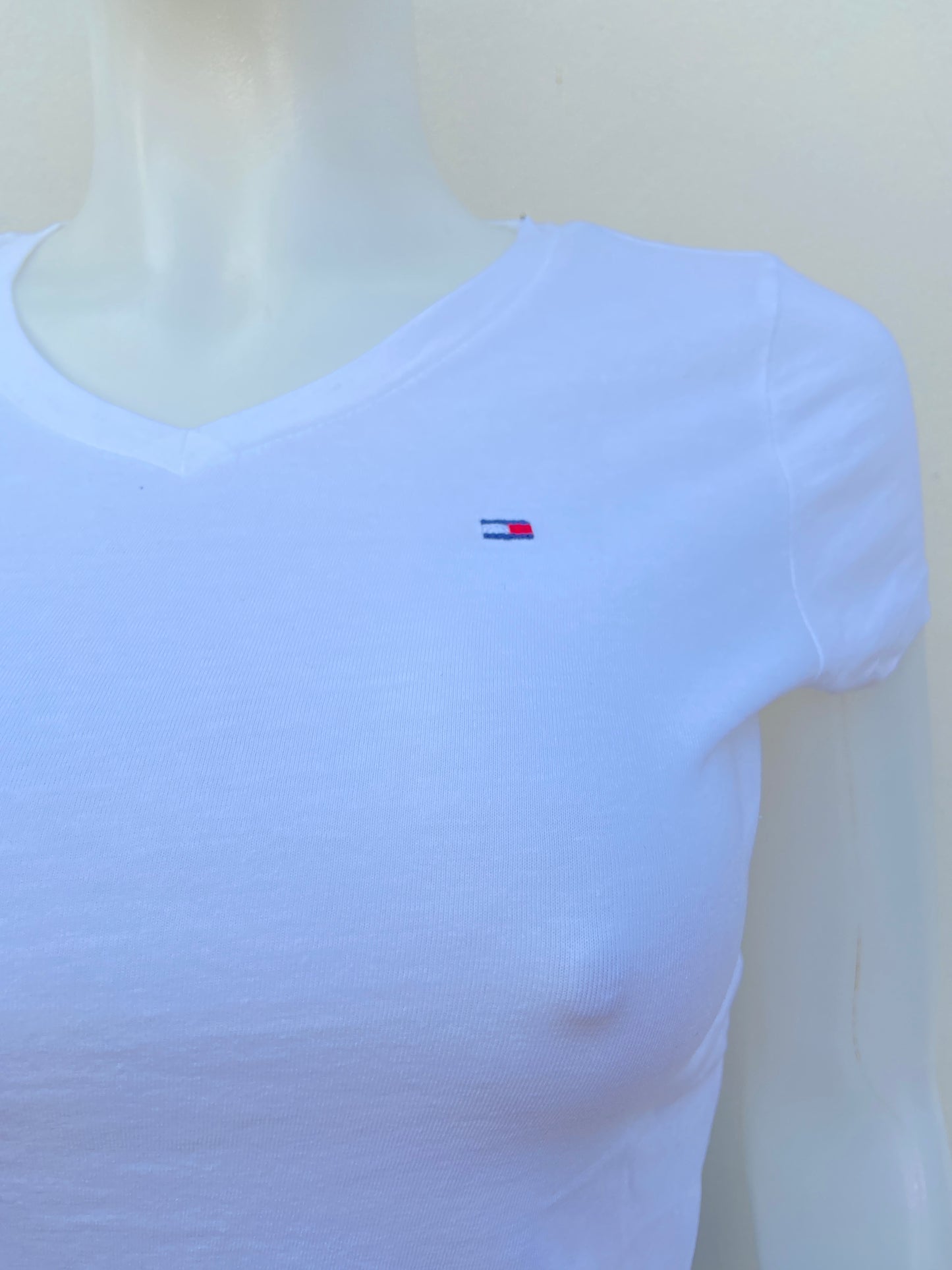 T-shirt Tommy Hilfiger original blanco con pequeño logotipo al lado y cuello en V.