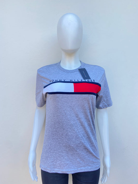 T-shirt Tommy Hilfiger original gris con banda Tommy Hilfiger en frente en rojo, blanco y azul.