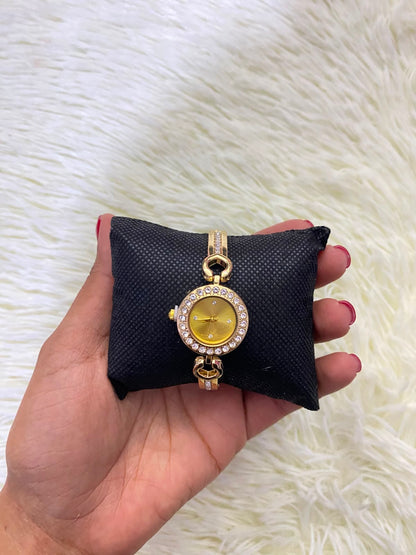 Reloj, dorado con detalles de  diamantes.