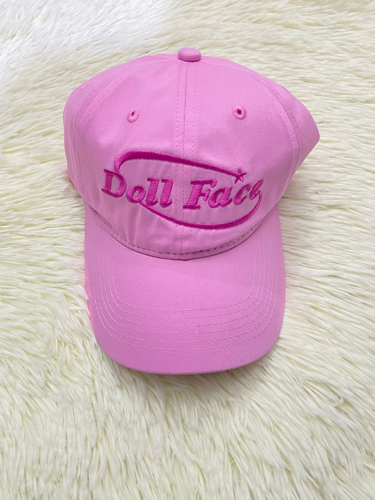 Gorra, rosada con letras DOLL FACE ( cara de muñeca).