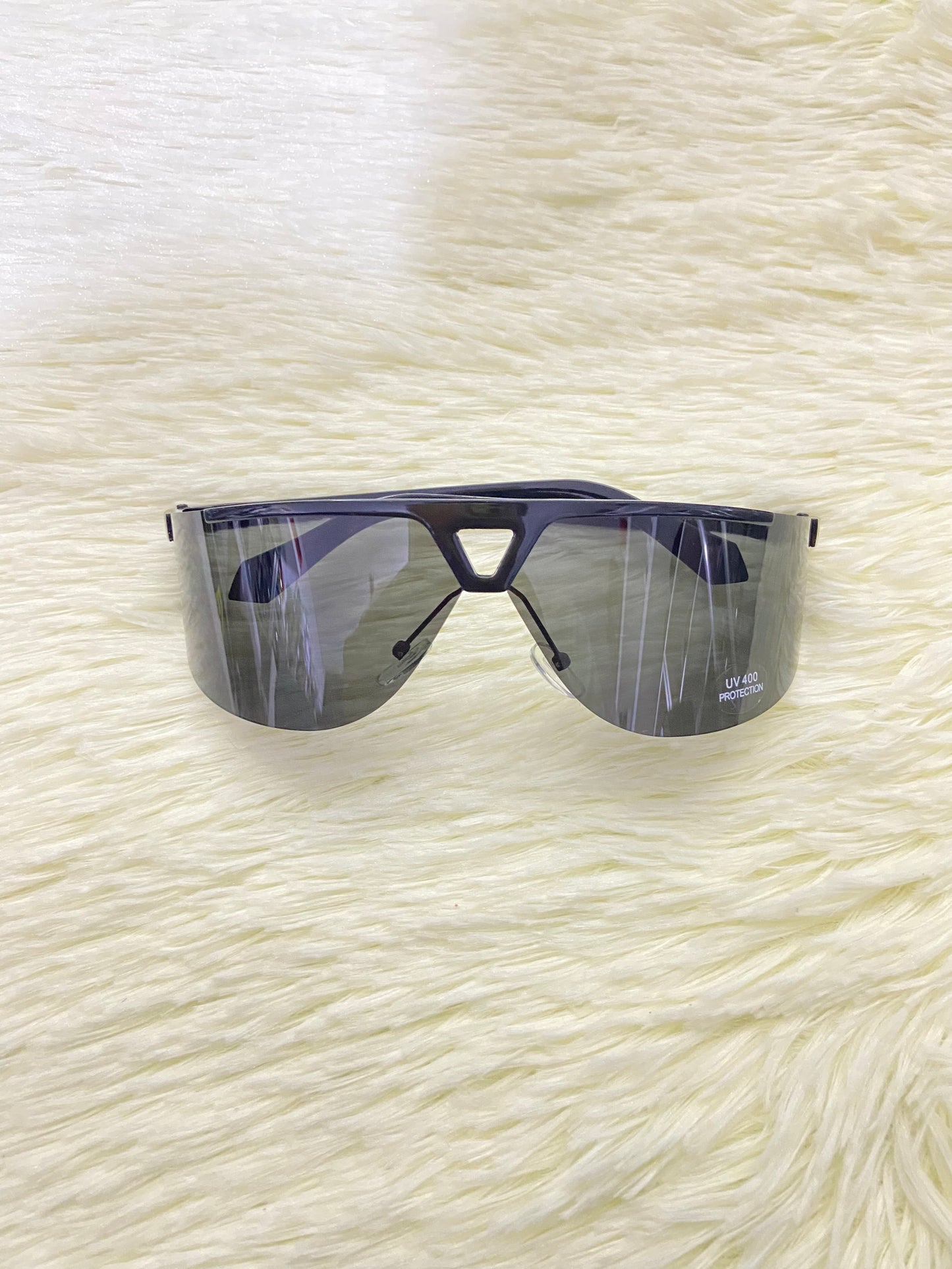 Lentes, negro con montura negro matte y triángulo en frente, protección UV 400.