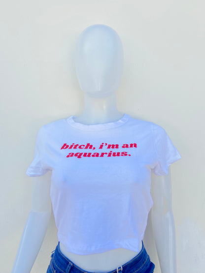 Top, blanco con letras BITCH I’M AN AQUARIUS ( Perra, soy acuario ) en rojo.