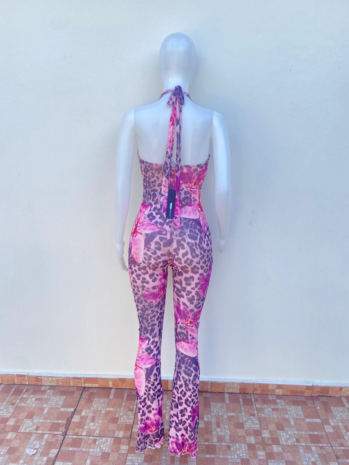 Enterizo, en color rosado con estampado de animal print y rosas largo con lazo ajustable en el cuello.