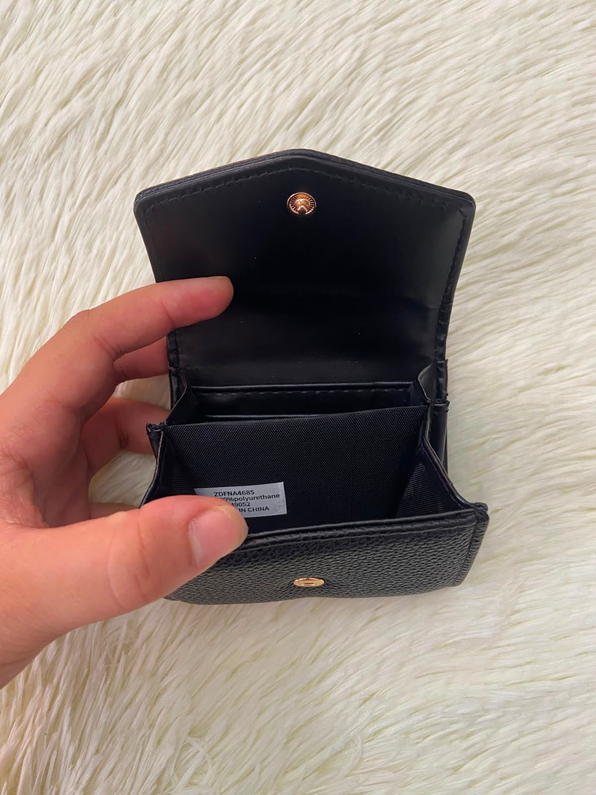 Monedero pequeño negro con diseño al frente en color dorado, cierre de boton y súper espacioso.