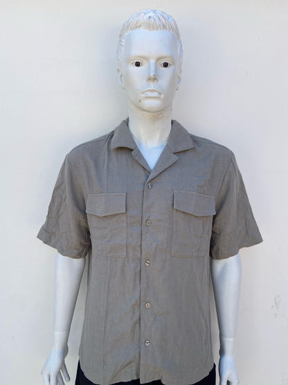 Camisa verde oliva con dos bolsillos en la parte del frente .