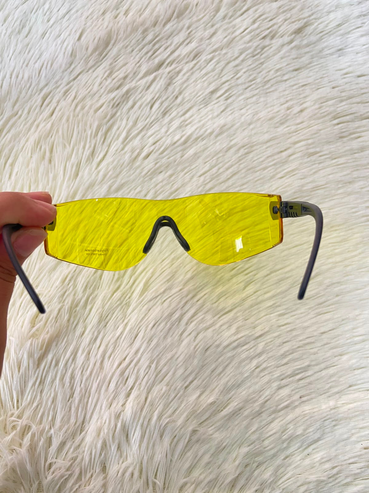 Lentes, sin montura con micas en color amarillo y patillas negras.