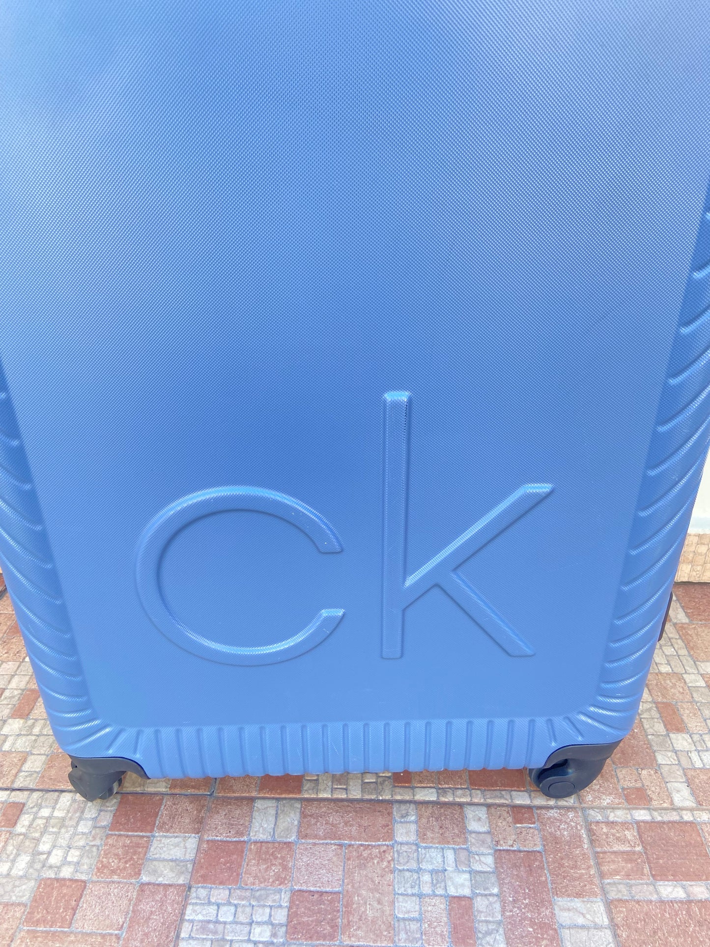 Maleta Calvin Klein original azul opaco con letras CALVIN KLEIN al lado.