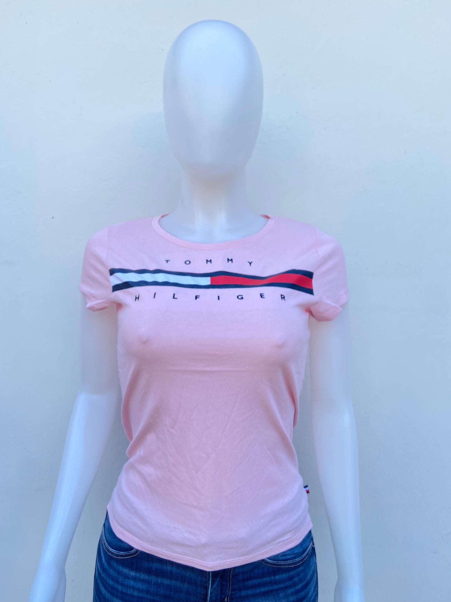 T-shirt Tommy Hilfiger original rosado claro con letras TOMMY HILFIGER en frente.