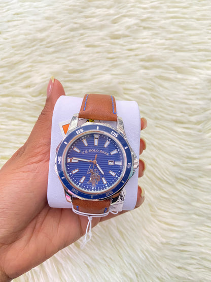 Reloj U.S POLO original, marron con costura en hilo azul, y fondo azul con plateado.