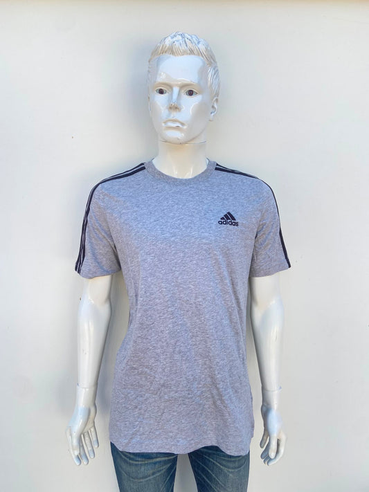 T-shirt ADIDAS original, en color gris con líneas de los hombros y logotipo de la marca al frente en color negro, 100% algodón.