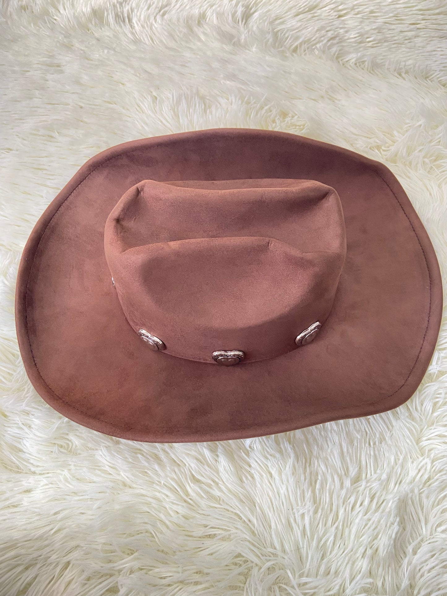 Sombrero, marron oscuro con placas de corazón al rededor en plateado, estilo vaquero.