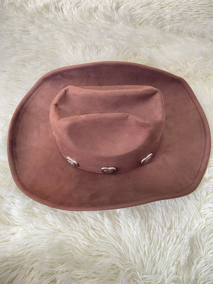 Sombrero, marron oscuro con placas de corazón al rededor en plateado, estilo vaquero.
