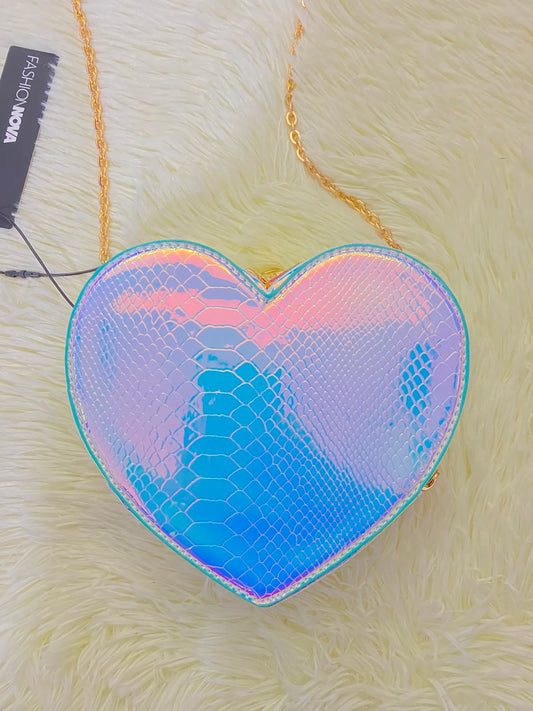 Cartera, color azul cambiante con la luz y forma de corazón mas acabado en estampado de escamas de sirena y Cadena dorada.