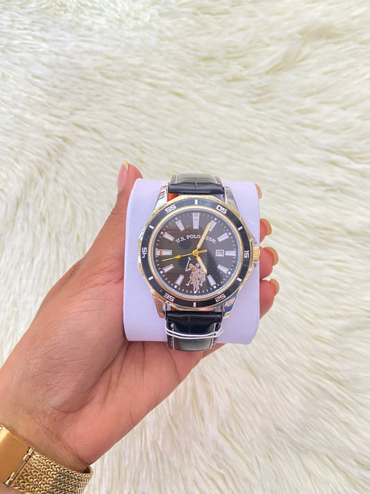 Reloj U.S POLO ASSN. SINSE 1890, negro con detalles en color dorado y plateado y correa con costura en hilo blanco.
