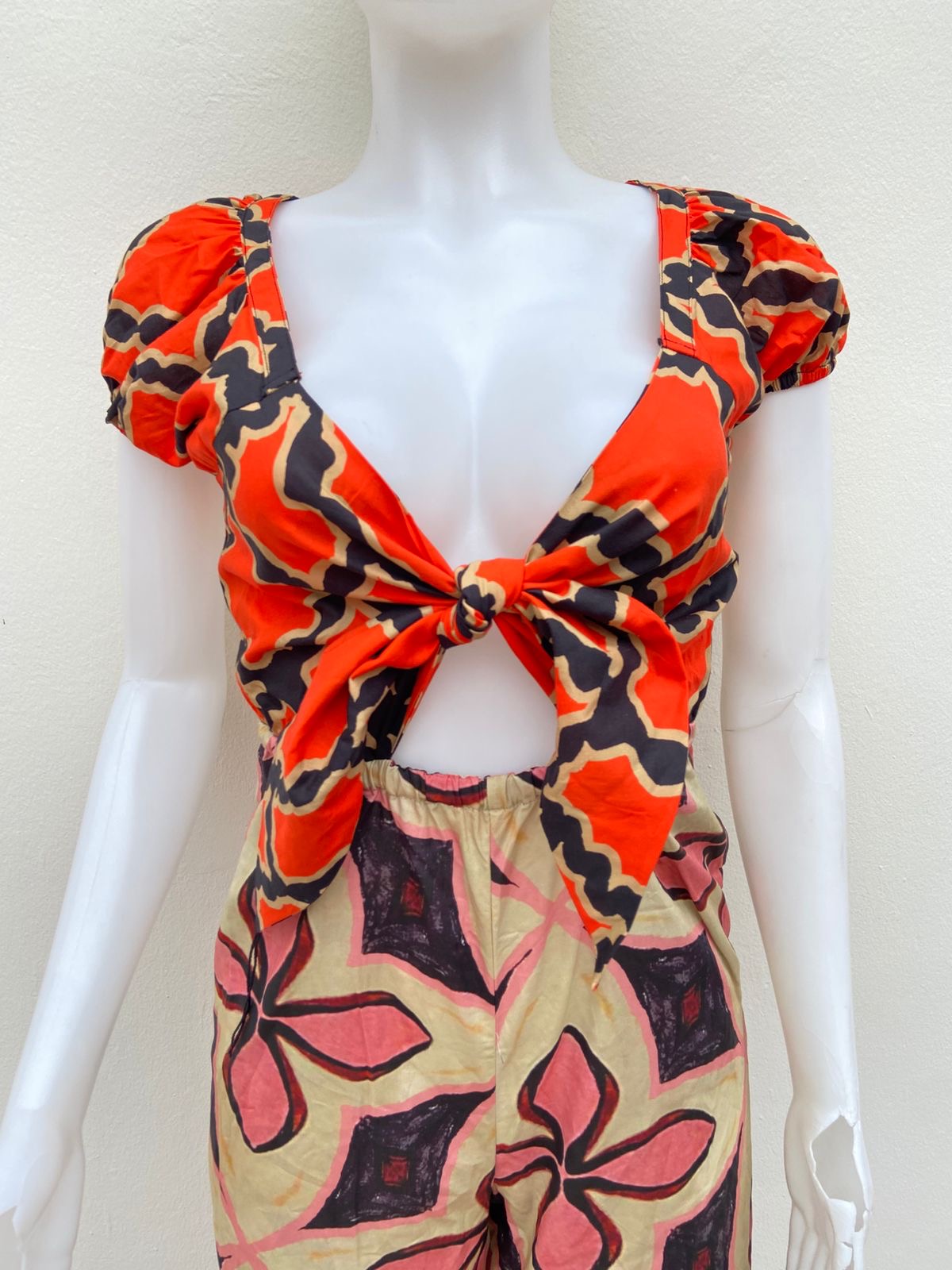 Enterizo, crema con naranja y estampado de flores en colores.