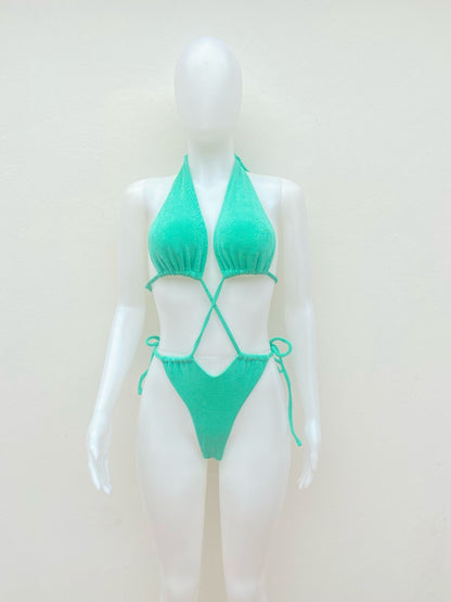 Biquini, de una pieza  verde con diseño de brillos y lazos ajustables.