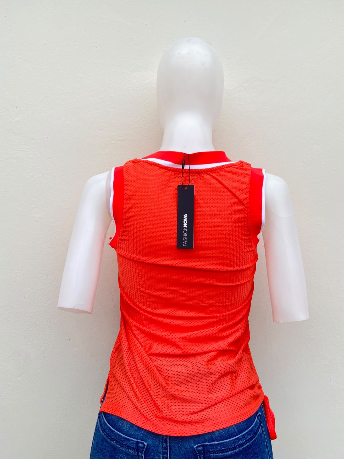 Top/ franela color naranja neón, con letras MIAMI 90 en blanco y negro.