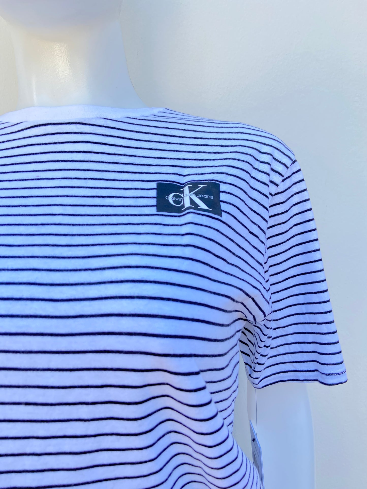 T-shirt Calvin Klein original blanco con rayas en color negro y logotipo CK al lado.