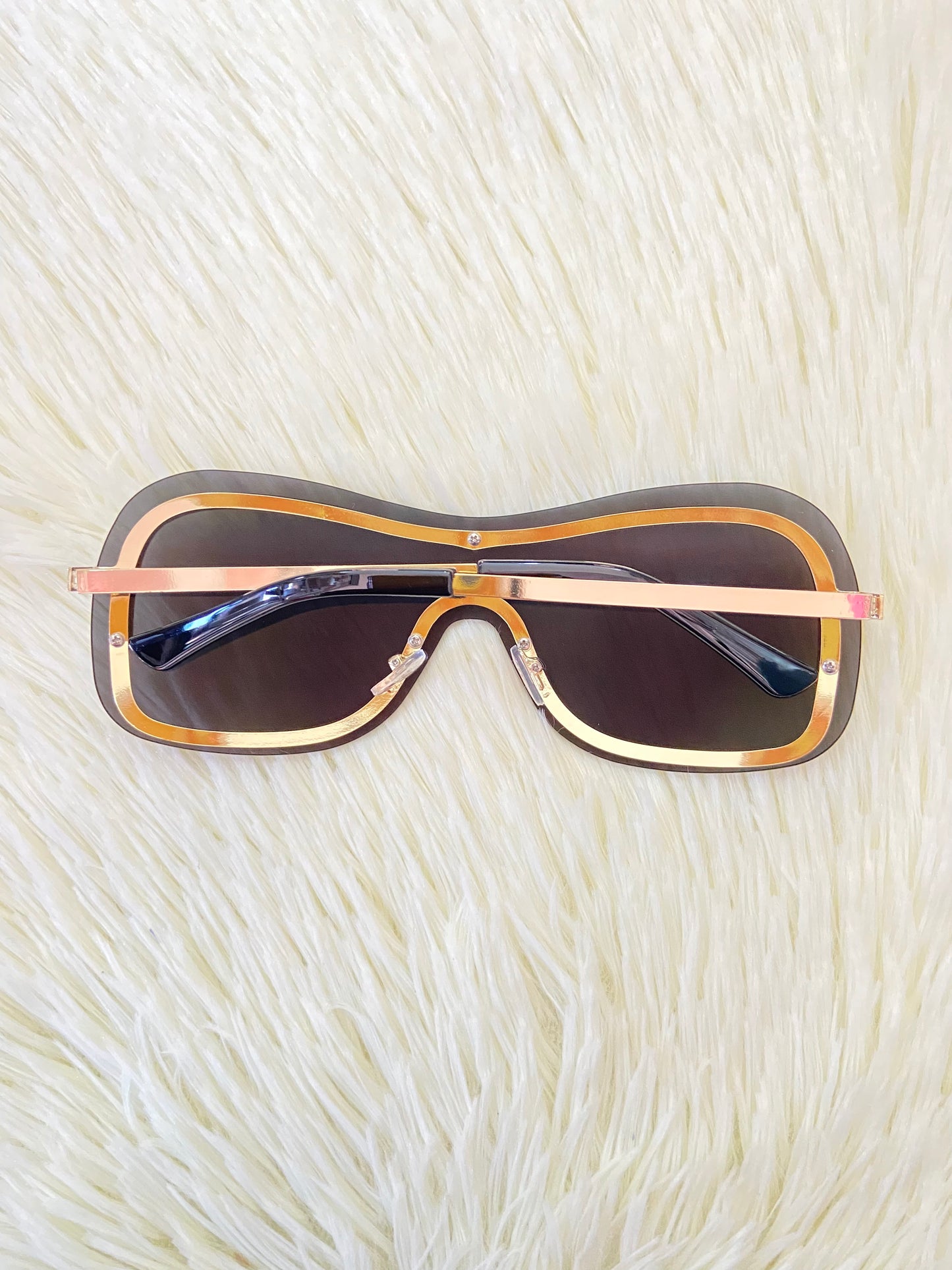 Lentes, negros, grandes curvos, con línea dorada al rededor y montura en  dorado.