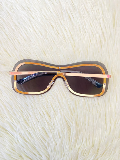 Lentes, negros, grandes curvos, con línea dorada al rededor y montura en  dorado.