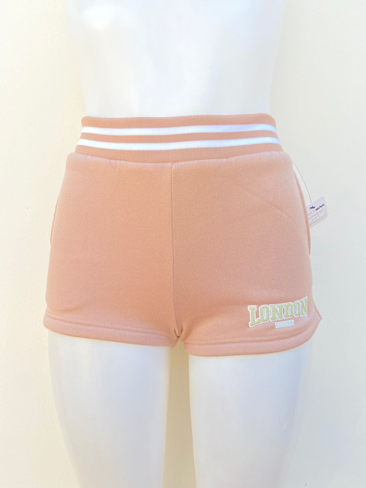 Short en color crema, pretina con lineas blancas y letra abajo en color verde LONDON