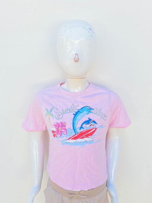 T-shirt/Crop top ZARA Original en color rosado con estampado al frente de una playa con un delfin, una palmera dos rosas y letra SUNLIT SHORES