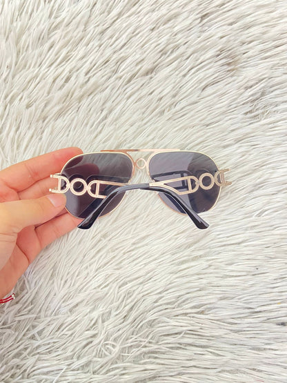 Lentes con protección UV 100-400 para proteger tu visión. Con montura en dorado y detalles en los lados.