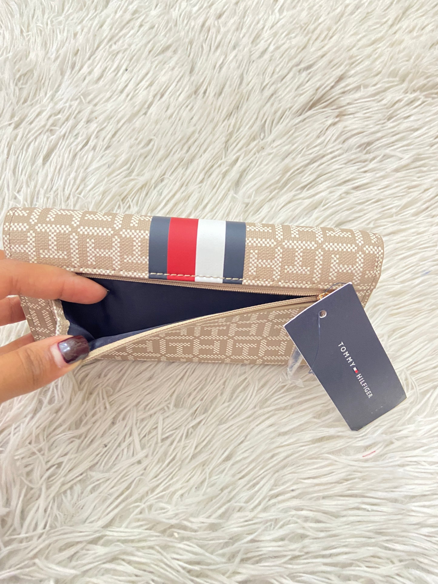 Monedero Tommy Hilfiger original marrón con estampado del logo de Tommy y franja azul, rojo y blanco, placa TH en dorado.