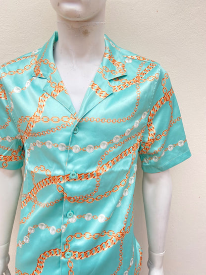 Camisa azul turquesa, con estampado de cadenas y perlas.