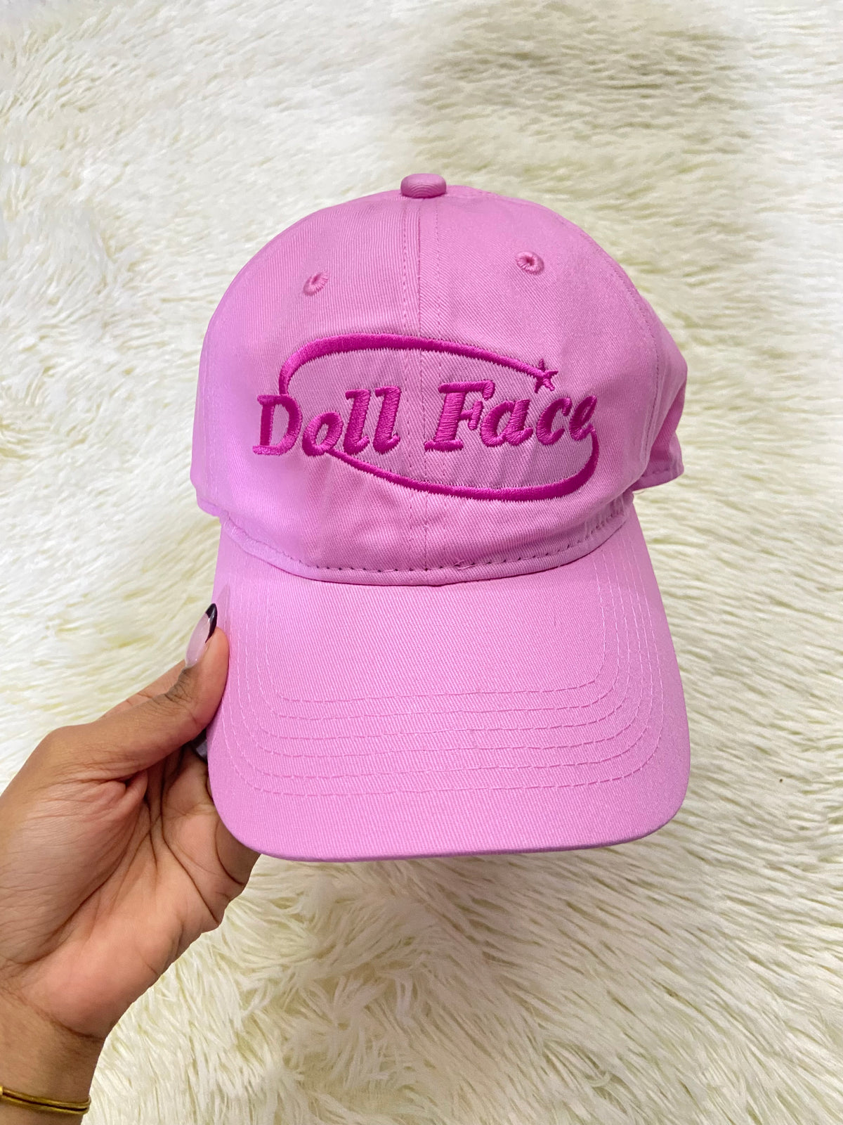 Gorra, rosada con letras DOLL FACE ( cara de muñeca).