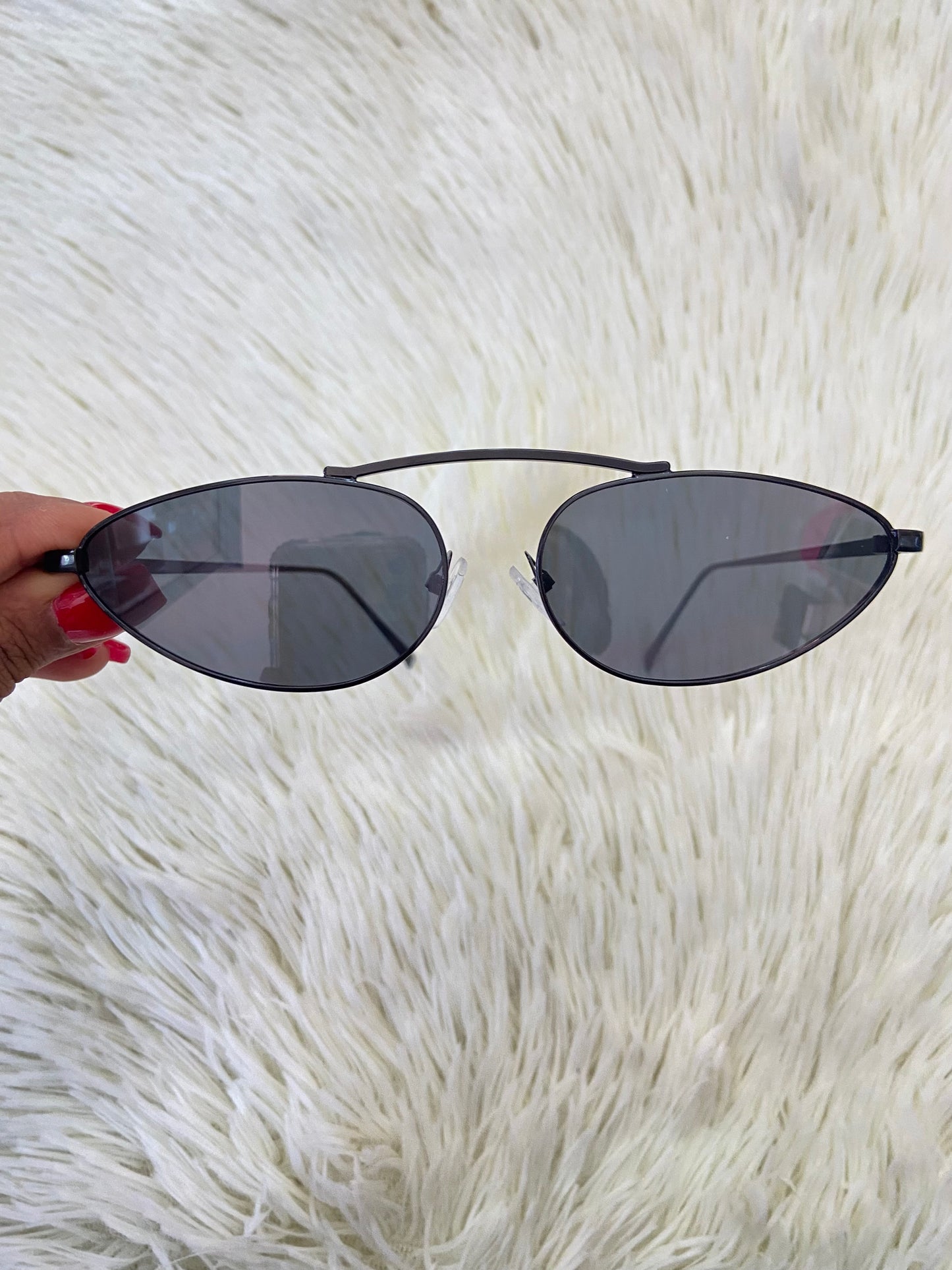 Lentes, negros pequeños con micas claras y montura fina.