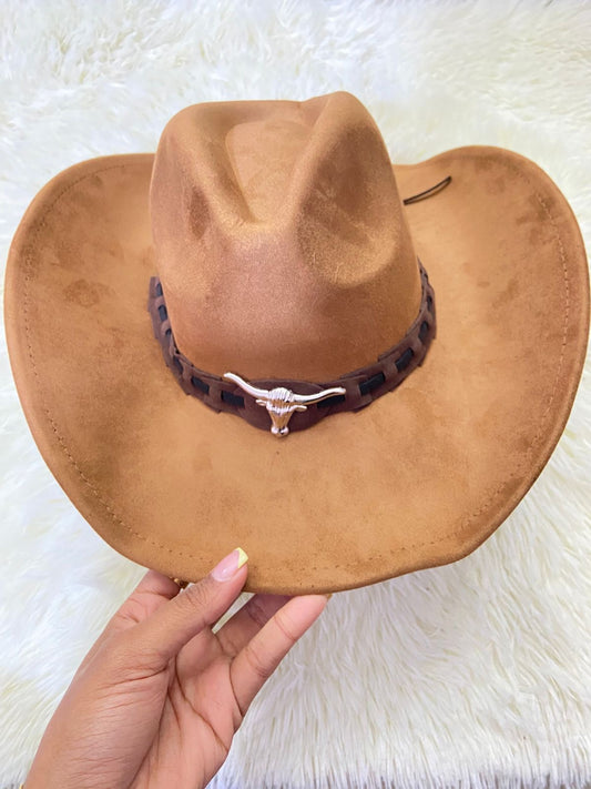 Sombrero, marrón con correa en frente y placa de un toro en plateado.