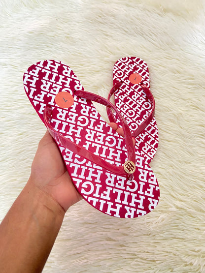Sandalias TOMMY HILFIGER original, rojo vino con letras HILFIGER en blanco y placa dorada en frente.