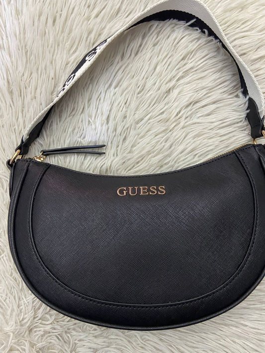 Cartera GUESS Original color negra con placa de la marca al frente y correa corta de color blanco y negro.